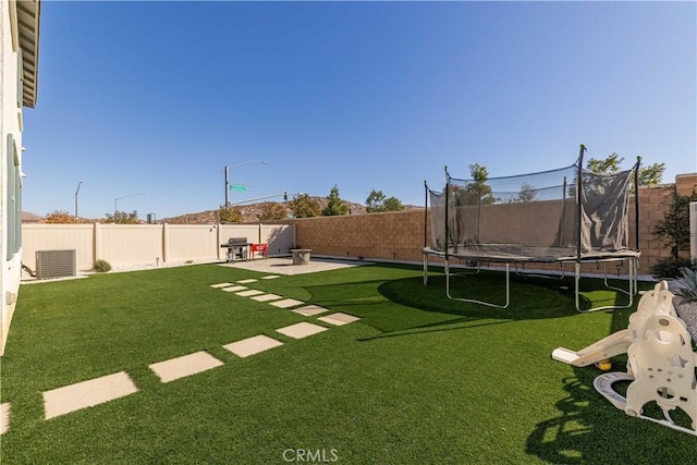 view of yard featuring a patio, a trampoline, and cooling unit