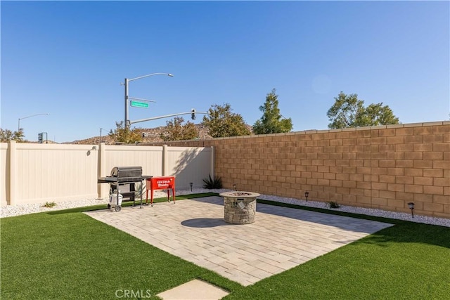 view of patio with area for grilling and an outdoor fire pit