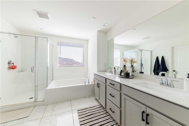 bathroom with vanity and shower with separate bathtub