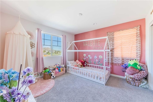 bedroom with carpet floors and a nursery area