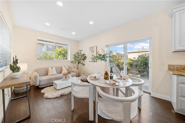 dining area with dark wood-type flooring and a healthy amount of sunlight