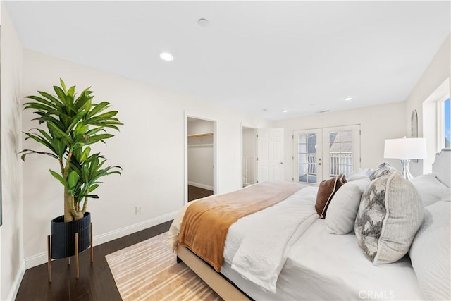 bedroom with access to exterior, french doors, dark hardwood / wood-style flooring, a walk in closet, and a closet