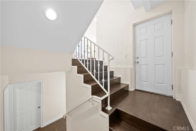 staircase featuring beam ceiling and wood-type flooring