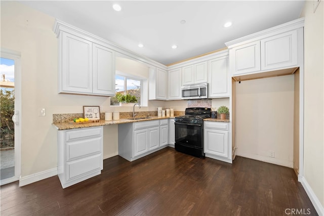 kitchen with white cabinets, black gas stove, dark hardwood / wood-style flooring, and sink