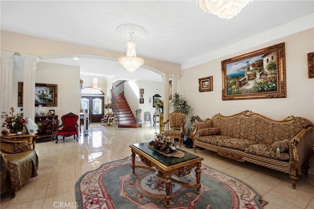 living room with a notable chandelier, decorative columns, and french doors