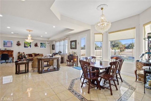 dining room featuring a chandelier, a raised ceiling, and light tile patterned flooring