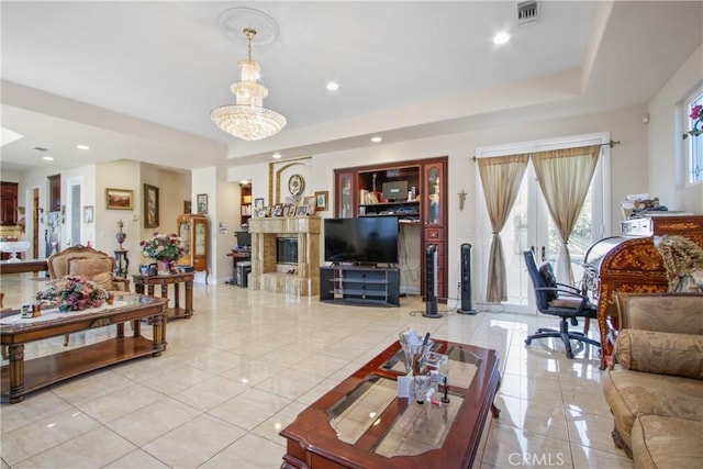 living room featuring light tile patterned floors, a raised ceiling, and a notable chandelier