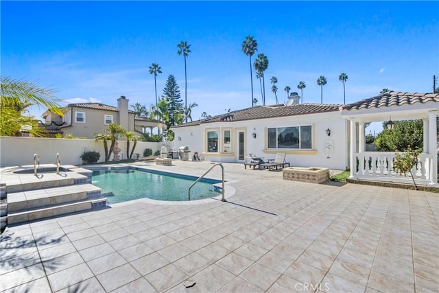 view of swimming pool featuring a patio area and an outdoor fire pit