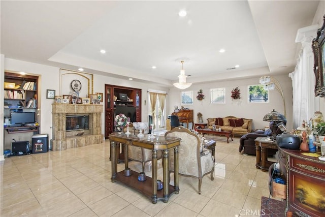 living room with a raised ceiling, a healthy amount of sunlight, and light tile patterned flooring