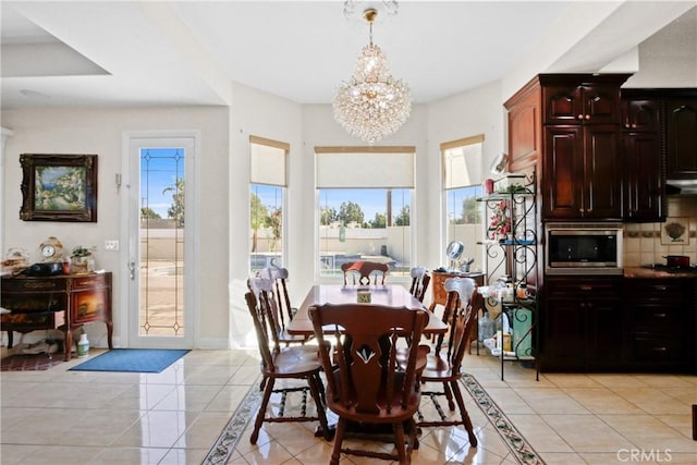 dining room with light tile patterned floors and an inviting chandelier