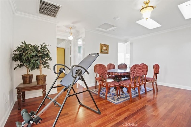 dining area with wood-type flooring and ornamental molding