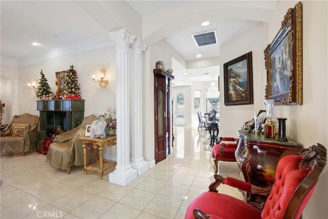 hallway with light tile patterned floors, ornamental molding, and decorative columns