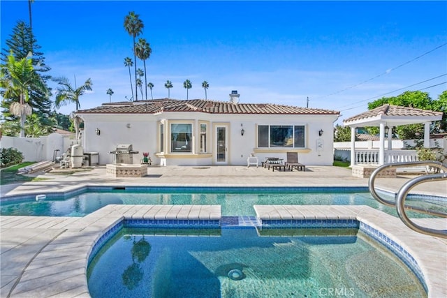 rear view of house with a gazebo, a patio, and a fenced in pool