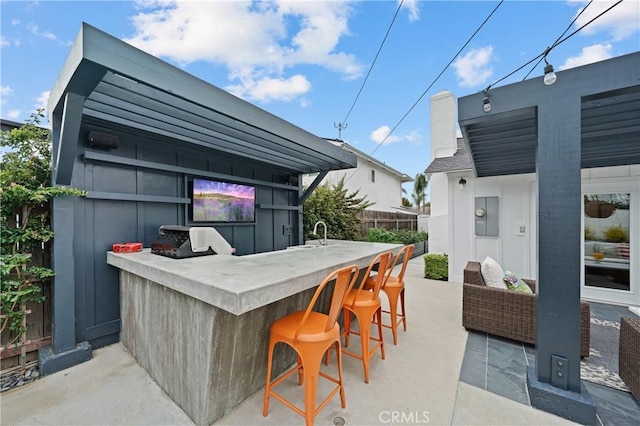 view of patio / terrace with an outdoor living space, exterior bar, and grilling area