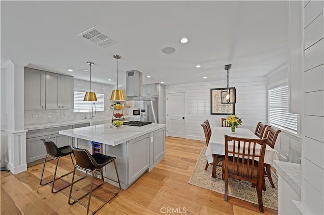 kitchen featuring gray cabinets, a center island, light hardwood / wood-style floors, and hanging light fixtures