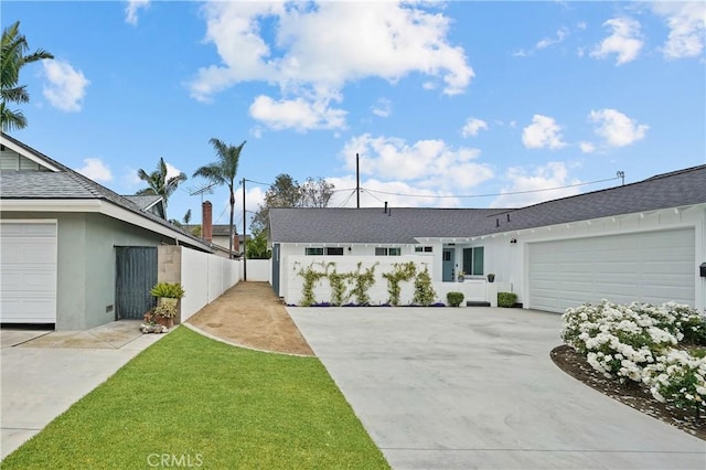 ranch-style house with a garage and a front lawn