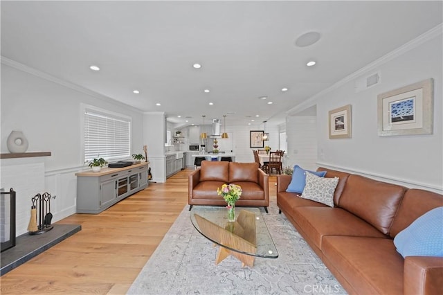 living room with light hardwood / wood-style flooring and ornamental molding