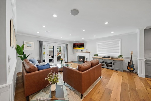 living room featuring french doors, light hardwood / wood-style floors, and ornamental molding