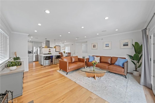 living room featuring light hardwood / wood-style flooring and ornamental molding