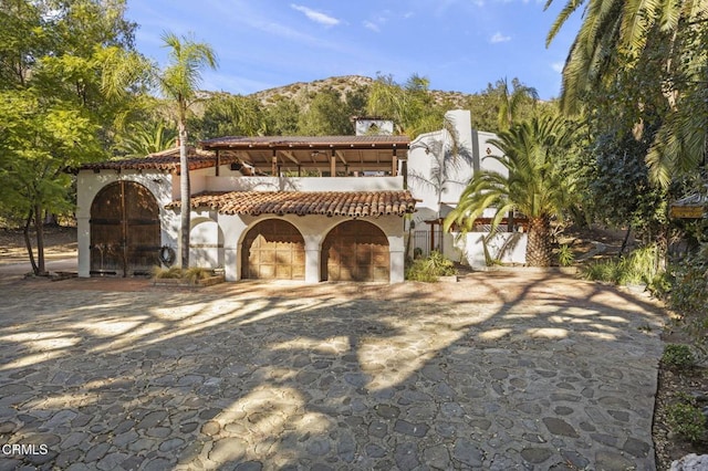 mediterranean / spanish house with a balcony, a garage, and a mountain view