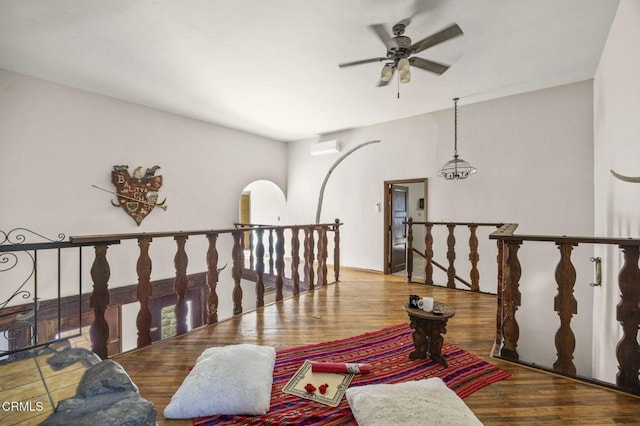 interior space featuring ceiling fan, hardwood / wood-style floors, and a wall unit AC