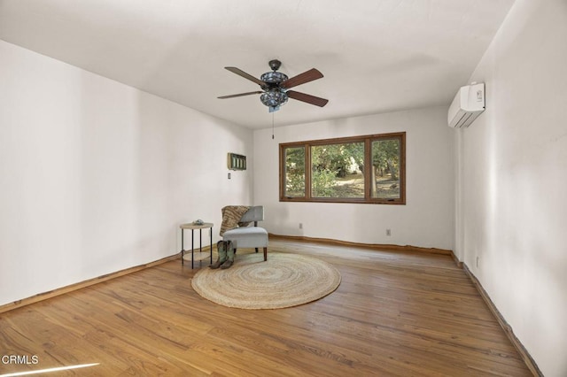 living area featuring ceiling fan, a wall mounted AC, and wood-type flooring