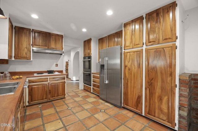 kitchen featuring black double oven, sink, white stovetop, light tile patterned floors, and high end refrigerator