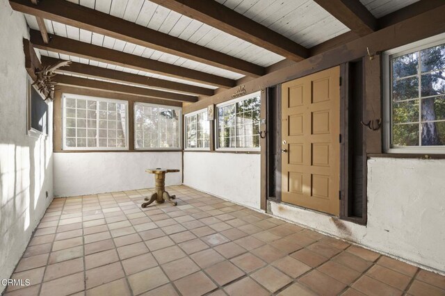 unfurnished sunroom featuring wooden ceiling and beam ceiling