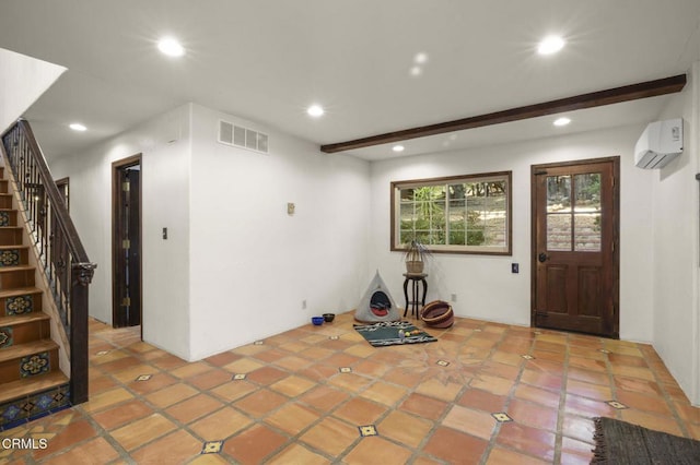 foyer entrance featuring a wall mounted AC and beam ceiling