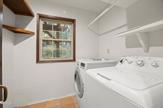 washroom with light tile patterned floors and washer and clothes dryer