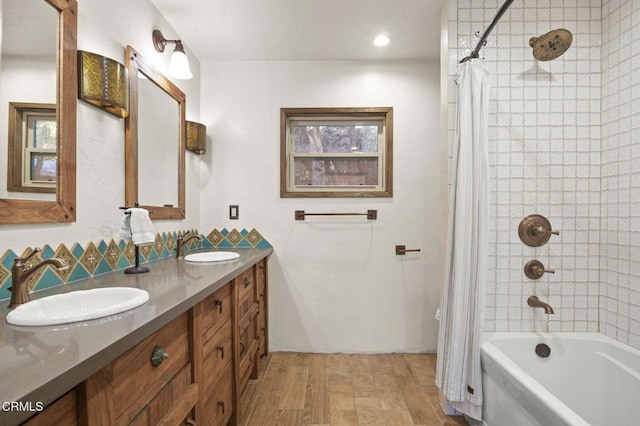 bathroom with wood-type flooring, vanity, and shower / bathtub combination with curtain