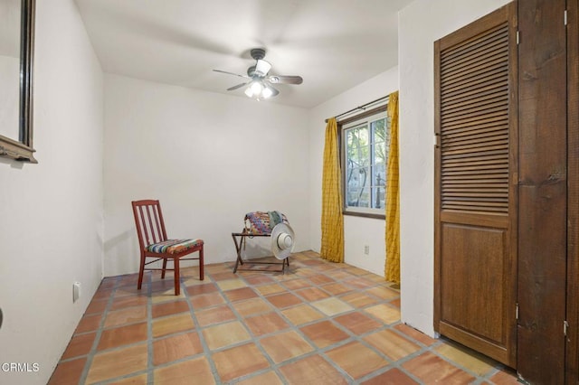 living area featuring ceiling fan and light tile patterned floors