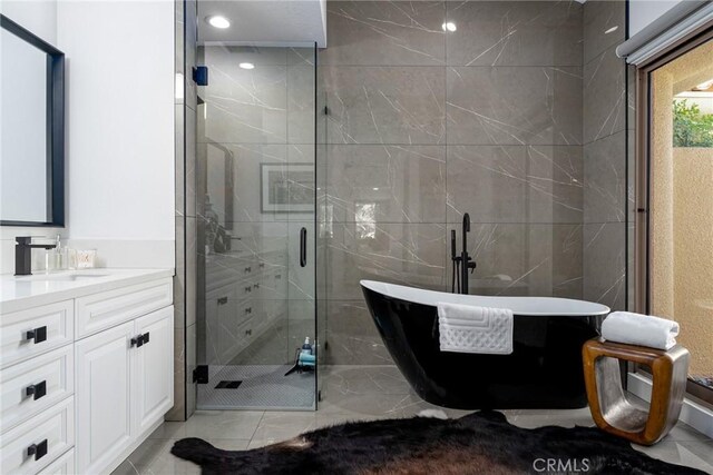 bathroom with vanity and shower with separate bathtub