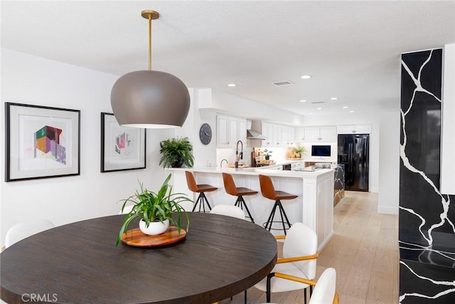 dining area with light hardwood / wood-style flooring and sink