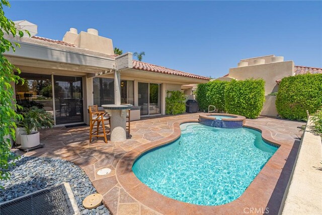 view of swimming pool with area for grilling, an in ground hot tub, and a patio