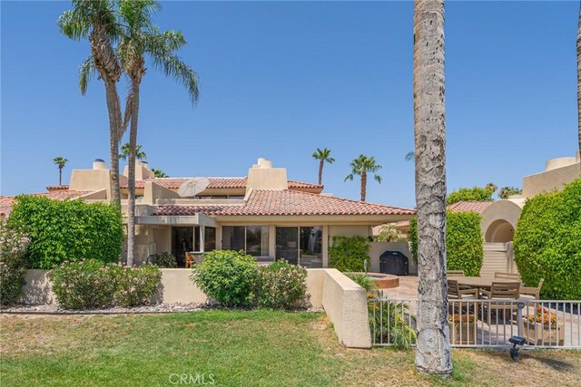 back of property with a patio area and a yard