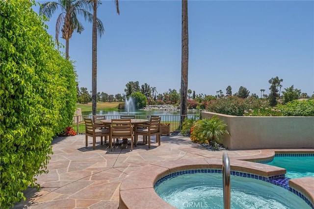 view of pool featuring an in ground hot tub, a patio, and a water view