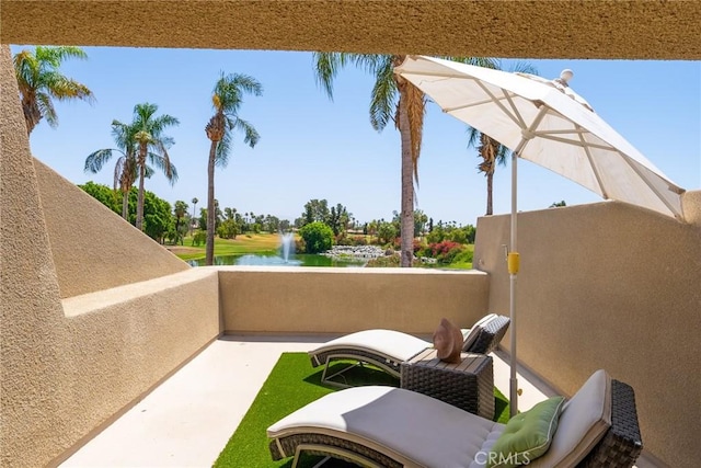 view of patio with a water view and a balcony