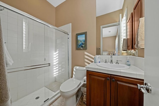 bathroom with tile patterned floors, vanity, an enclosed shower, and toilet