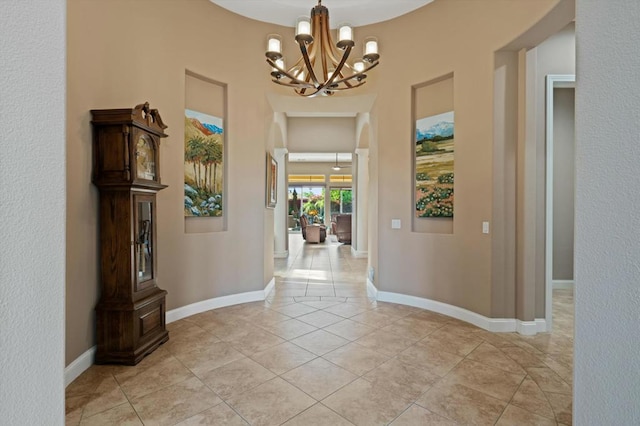 hall with light tile patterned floors and a chandelier