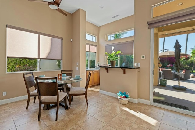 dining room featuring ceiling fan, plenty of natural light, and light tile patterned floors