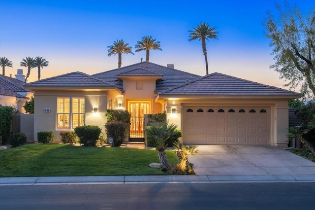 view of front of property featuring a yard and a garage