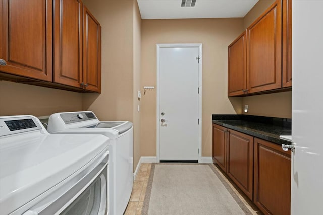 washroom featuring washer and clothes dryer, light tile patterned floors, and cabinets