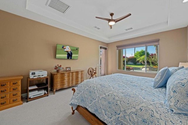 bedroom with ceiling fan, a raised ceiling, and carpet floors