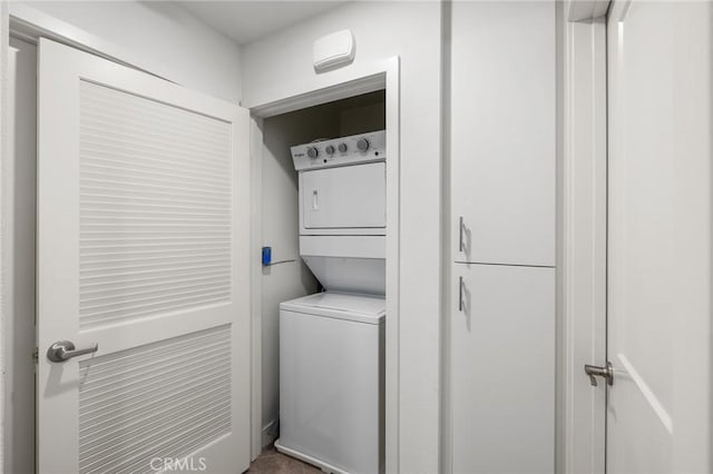 washroom with stacked washing maching and dryer