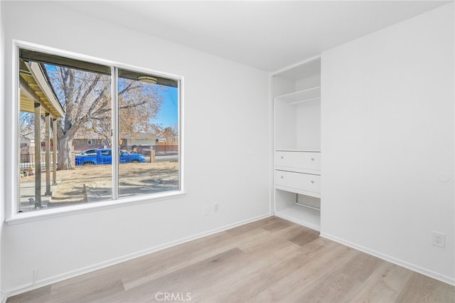 unfurnished bedroom with light wood-type flooring and multiple windows