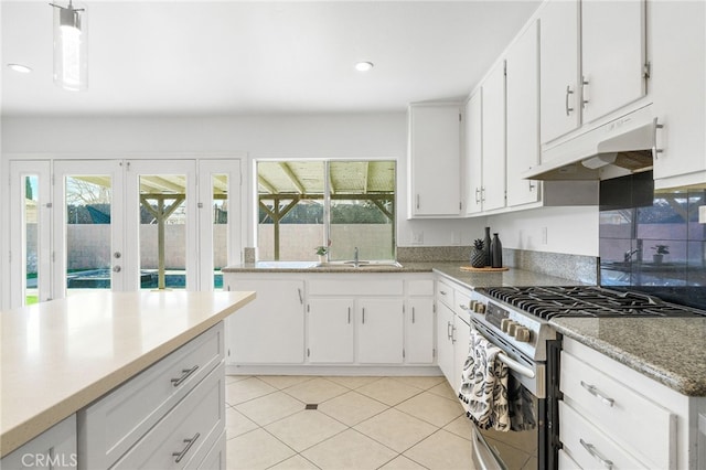 kitchen featuring white cabinets, decorative light fixtures, french doors, and gas range