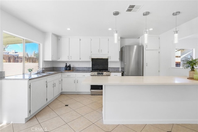 kitchen featuring white cabinetry, sink, stainless steel appliances, and decorative light fixtures