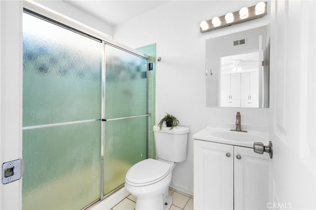 bathroom featuring vanity, tile patterned floors, ceiling fan, toilet, and a shower with shower door