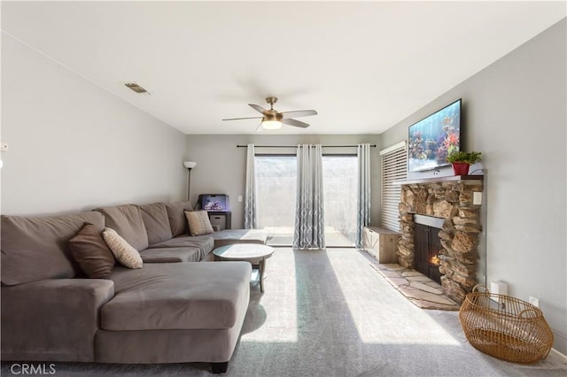 living room with ceiling fan, light carpet, and a fireplace